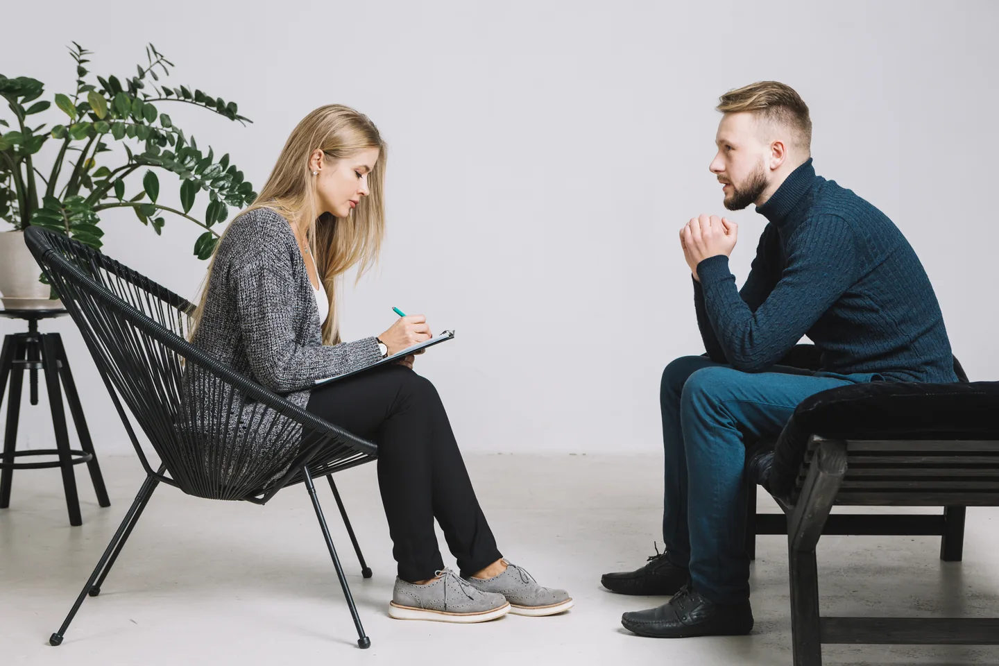 Psychologist listening and taking notes during a trauma therapy session
