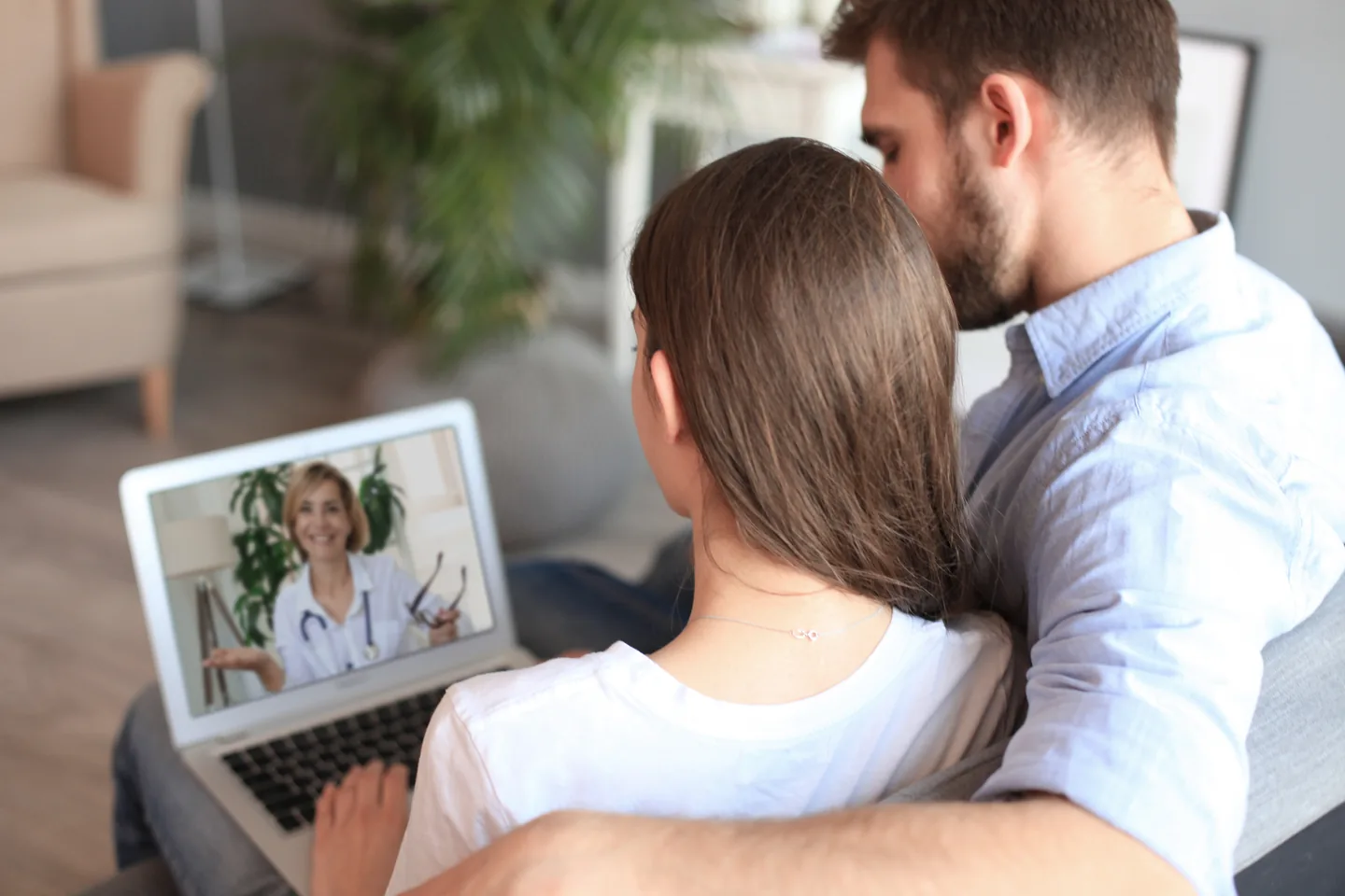 Couple attending an online couples therapy session on a laptop
