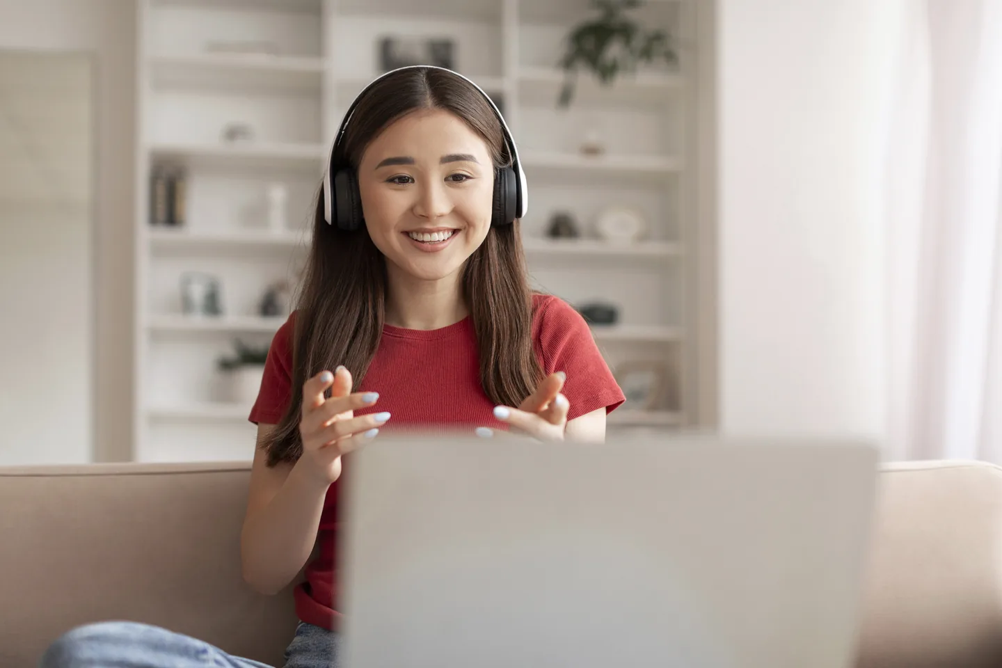 Teenager wearing headphones during an online therapy session on a laptop